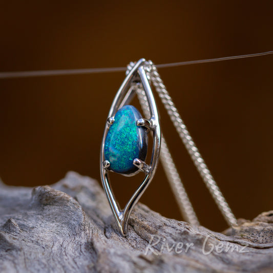 No bail needed with chain passing through the space included in the pendant design. Green/blue black opal is held securely with 4 claws in the leaf shaped design of the necklace.