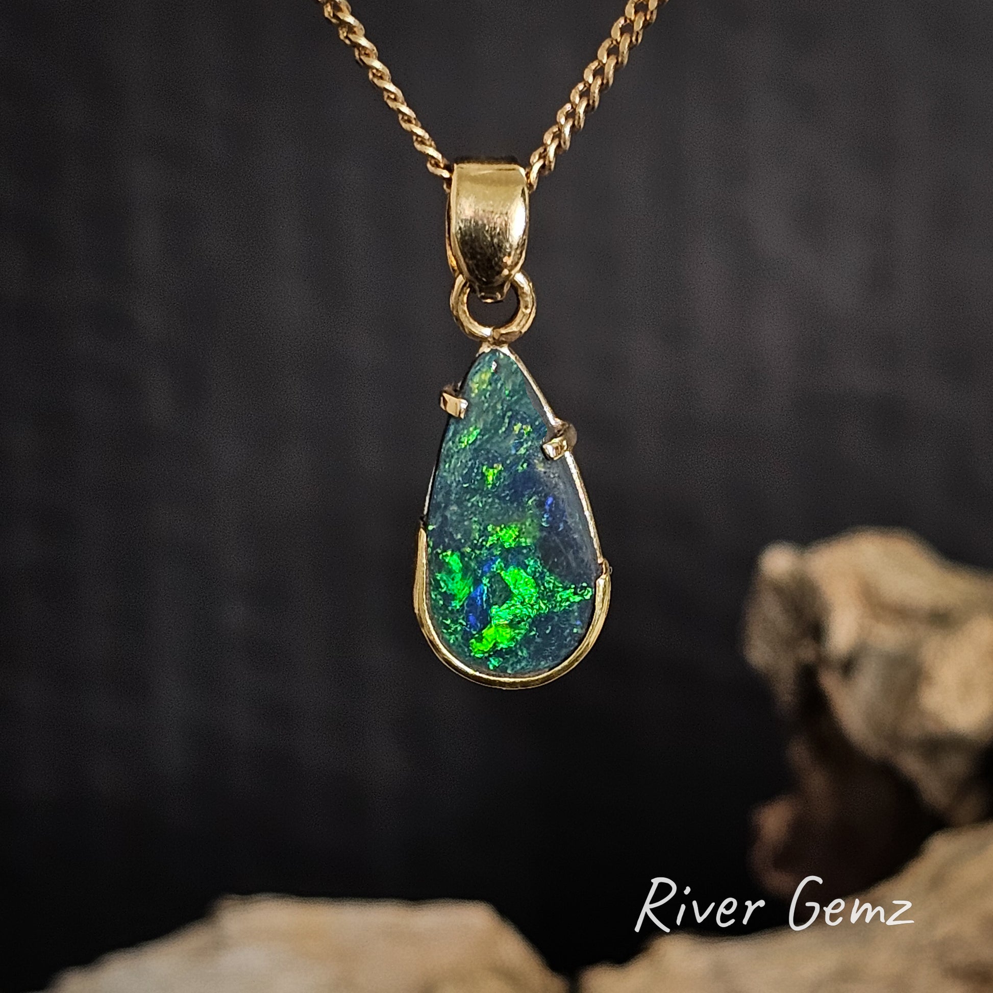 Gold pendant with a green black opal on a dark background, featuring 'River Gemz' branding.