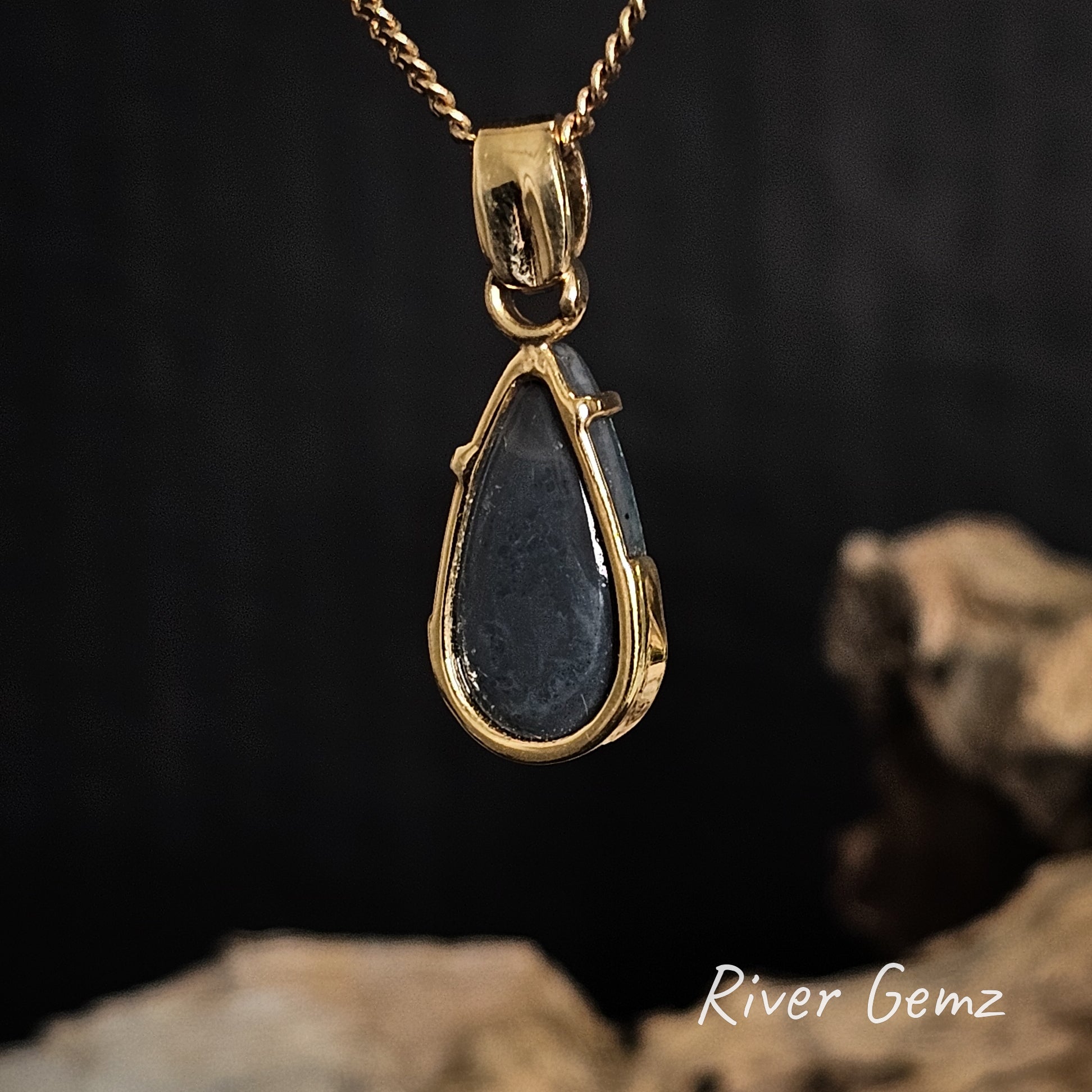 Rear of gold pendant showing the dark base of the black opal.