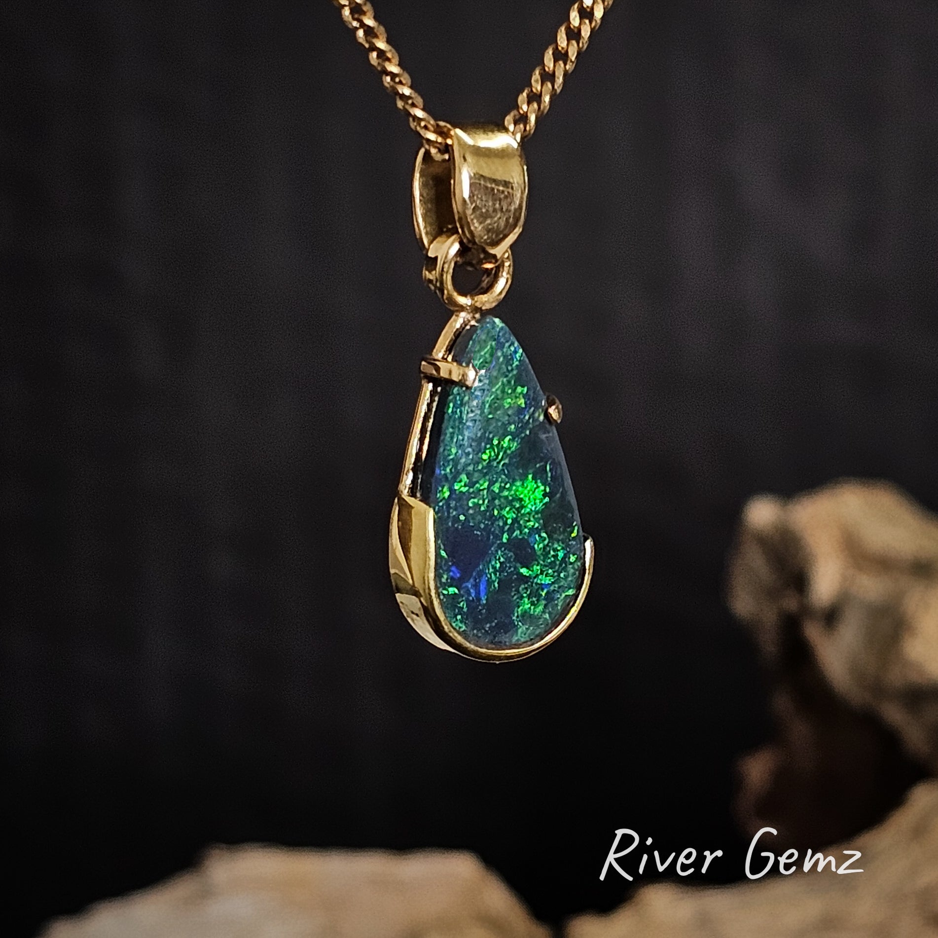 Yellow gold pendant with a green opal stone on a dark background, featuring 'River Gemz' branding.