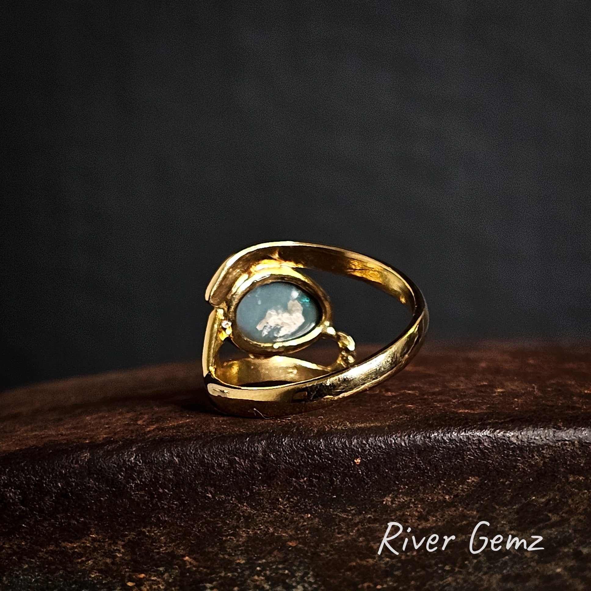 Rear view of gold ring showing the dark base tone of the black opal and natural inclusions in the stone.