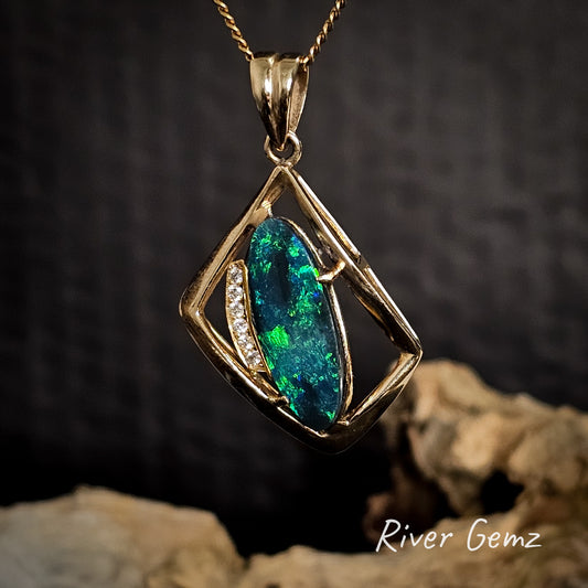 Gold pendant with a green dark opal and diamonds on a dark background.