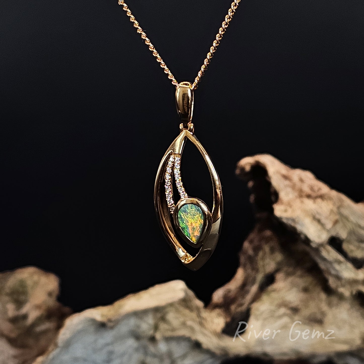 Gold pendant with a green gemstone on a dark background