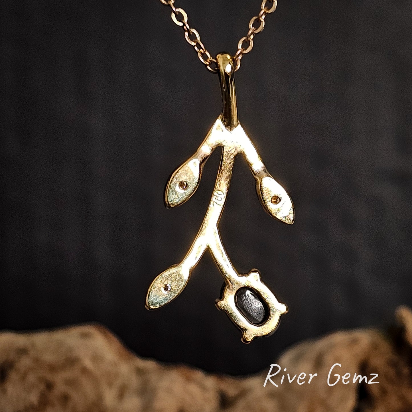 Back of necklace showing both the 750 stamp to indicate 18K gold and the dark base tone of the black opal.