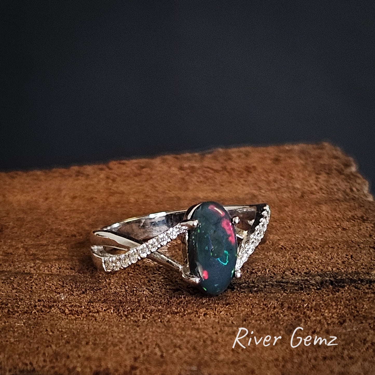 Diamonds are on each shoulder of the ring and the black opal centre stage.