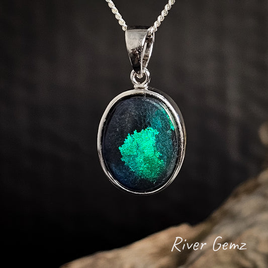 Silver pendant with a green and blue coloured black opal on a dark background, featuring 'River Gemz' branding.