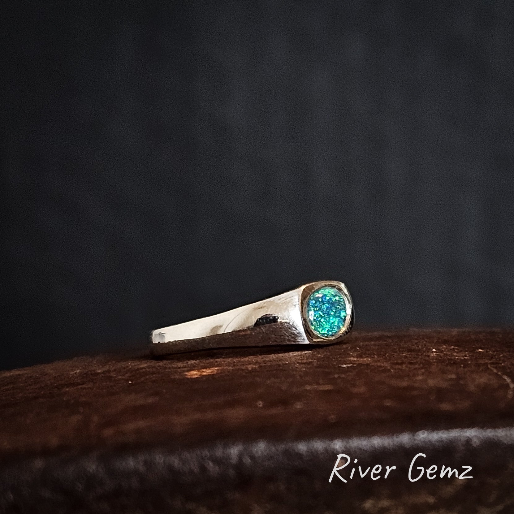 Side view of the silver ring shows the tapering of the band on a dark background, featuring 'River Gemz' branding.