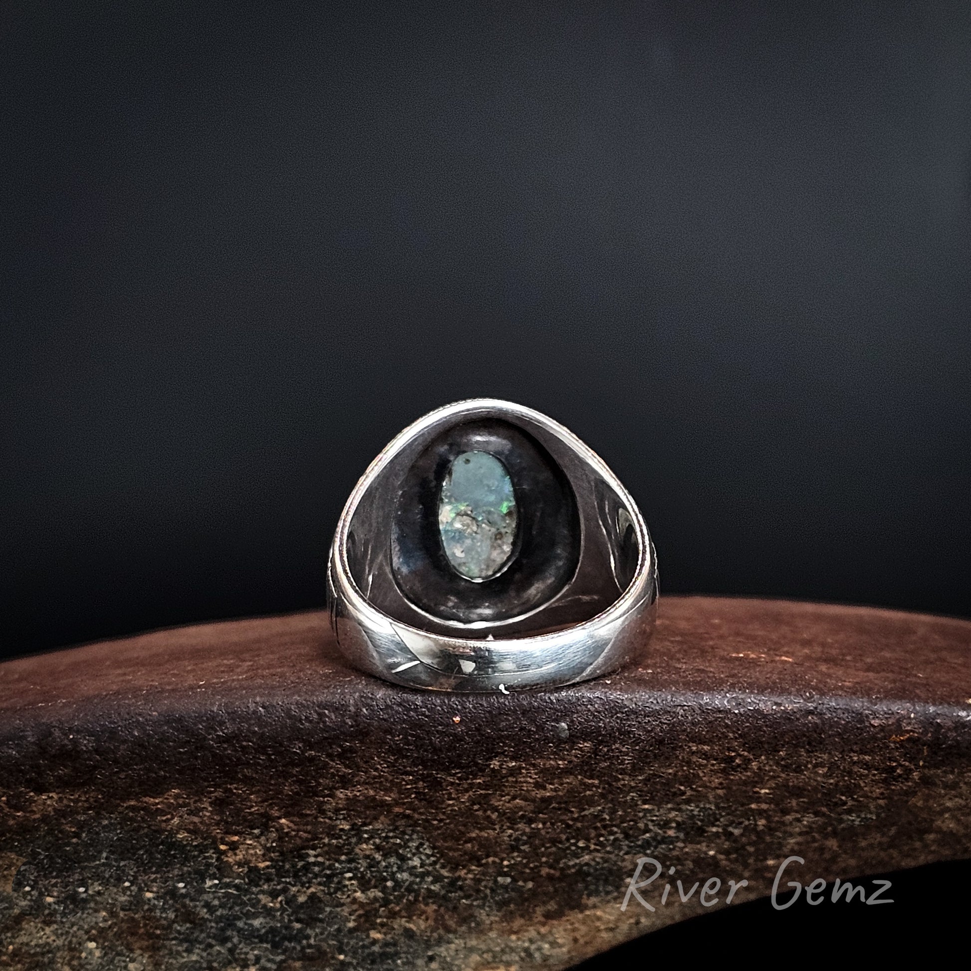 Rear view showing the dark base tone of the black opal set in the sterling silver ring.