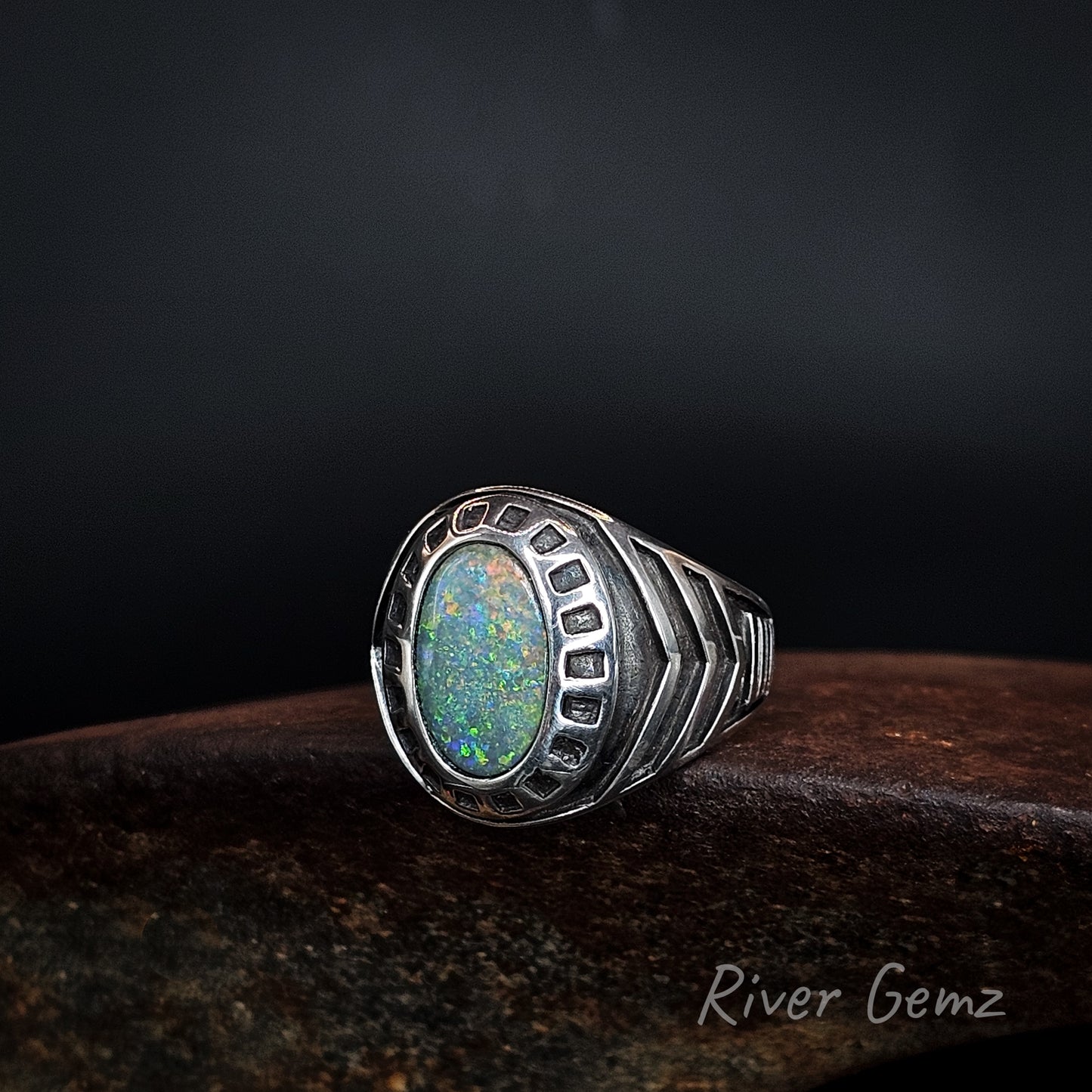 Large men's silver ring with oval shaped multi-coloured black opal.
