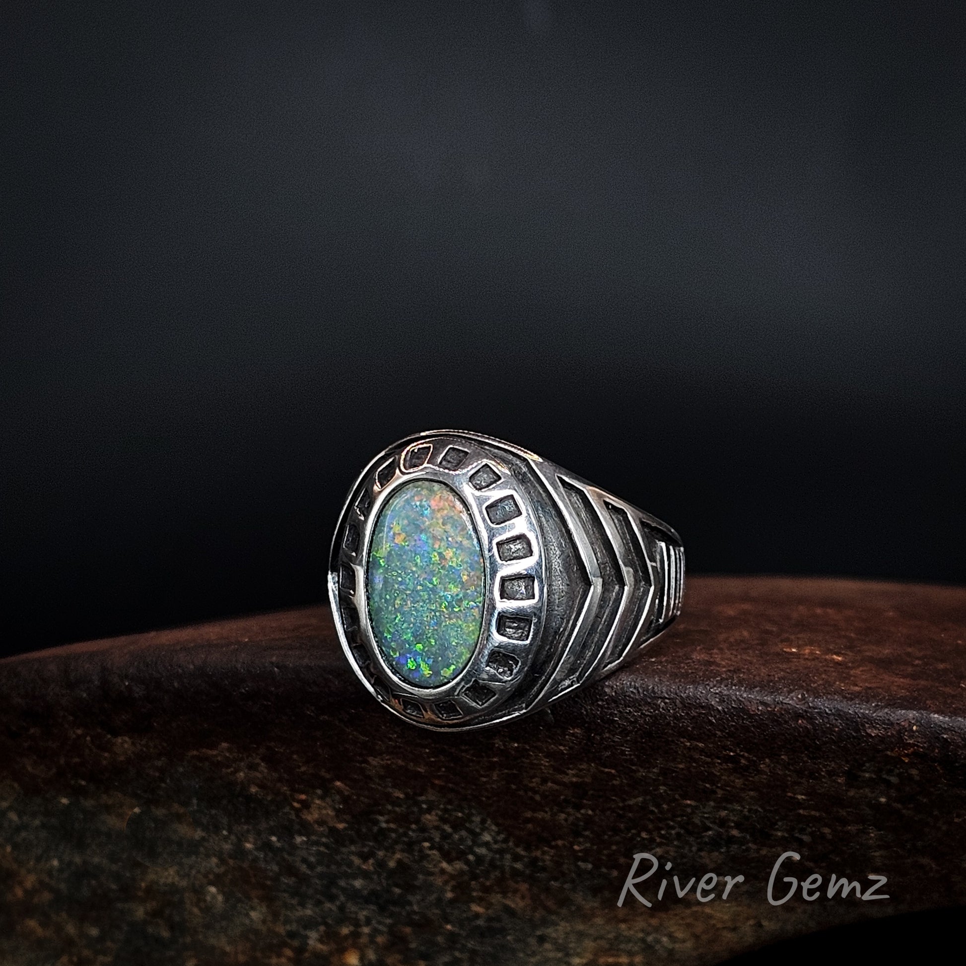 Large men's silver ring with oval shaped multi-coloured black opal.