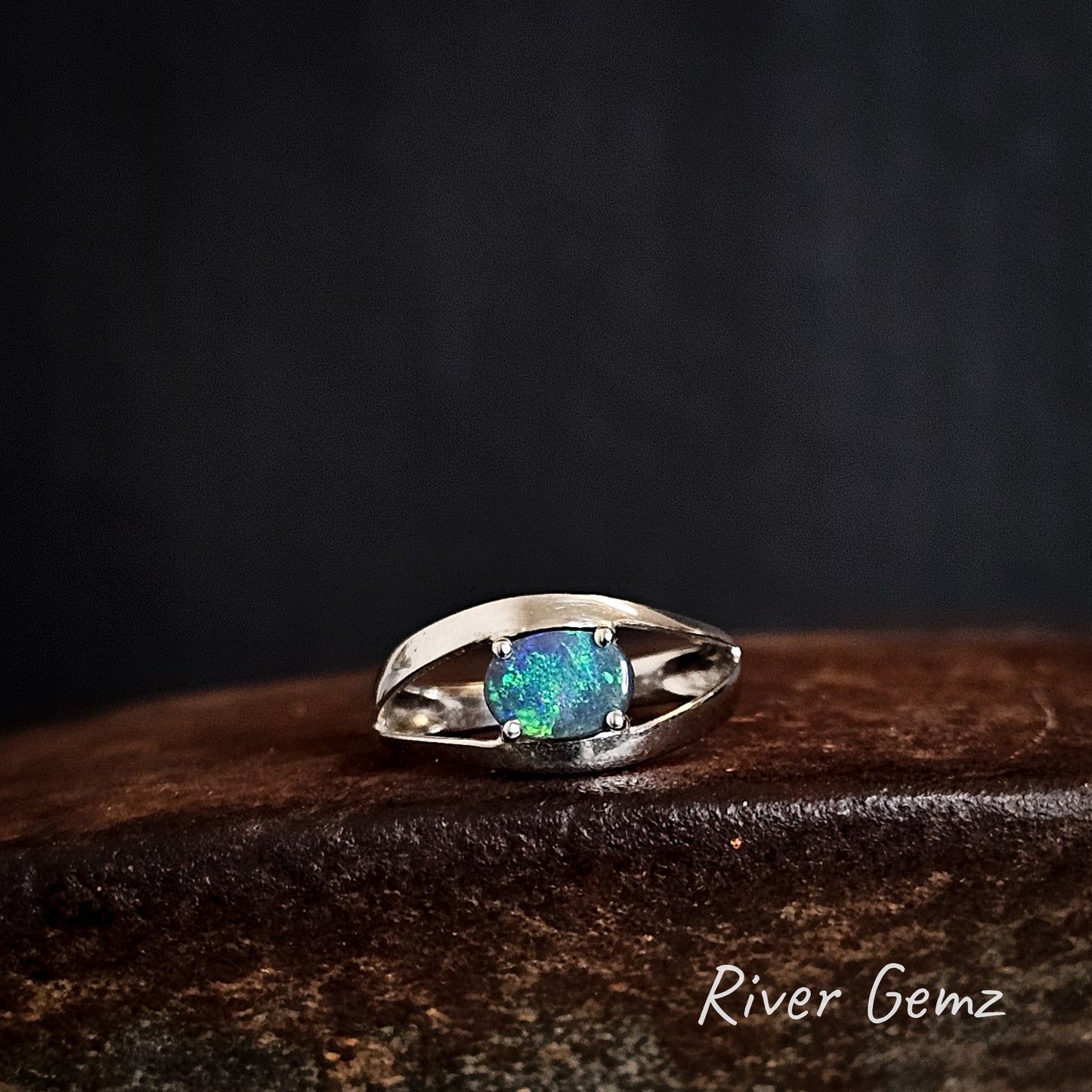 Oval shaped blue and green opal claw set in sterling silver ring.