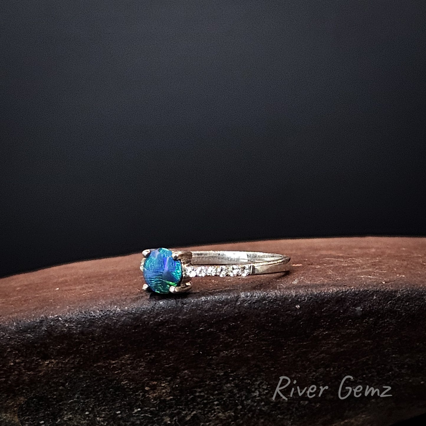 Round blue and green dark opal and white topaz stones in sterling silver ring.