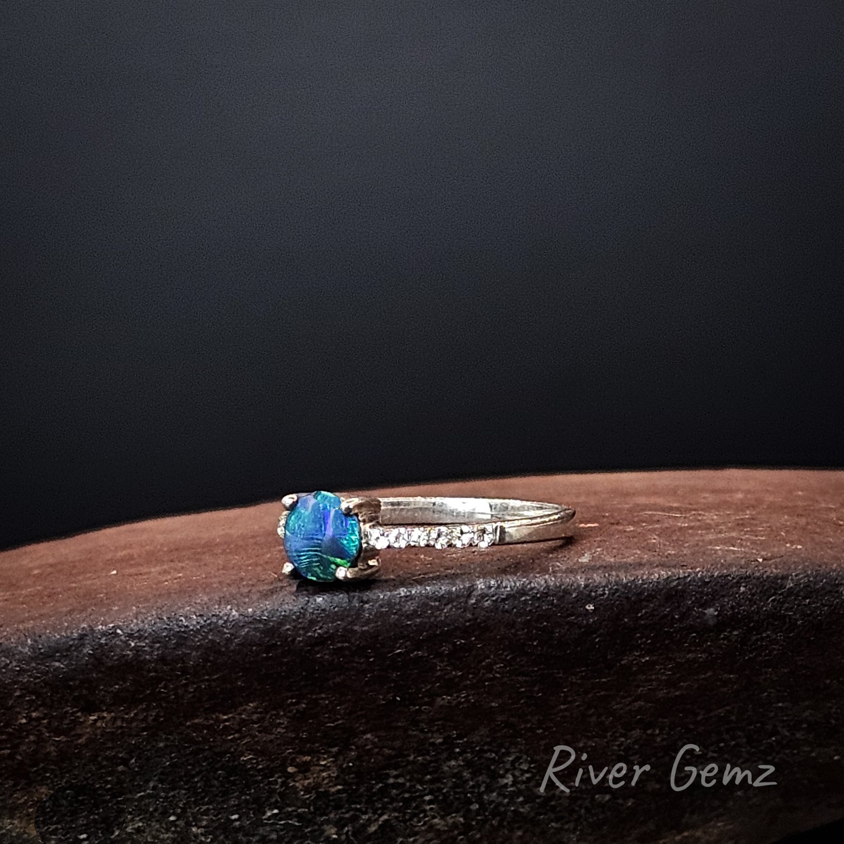 Round blue and green dark opal and white topaz stones in sterling silver ring.