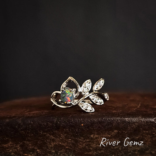 Silver ring with black opal and white topaz stones on a dark background, featuring 'River Gemz' branding.