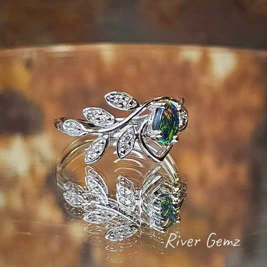 Black opal mainly green but with some orange flecks set in silver ring with 5 leaves adorned with white topaz.