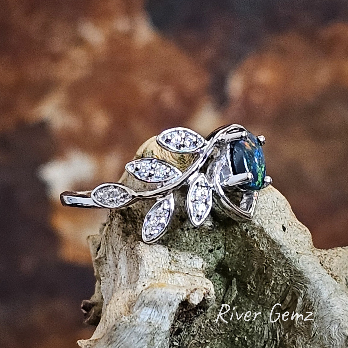 Side view shows the thickness of the black opal held with 4 claws in the sterling silver ring.