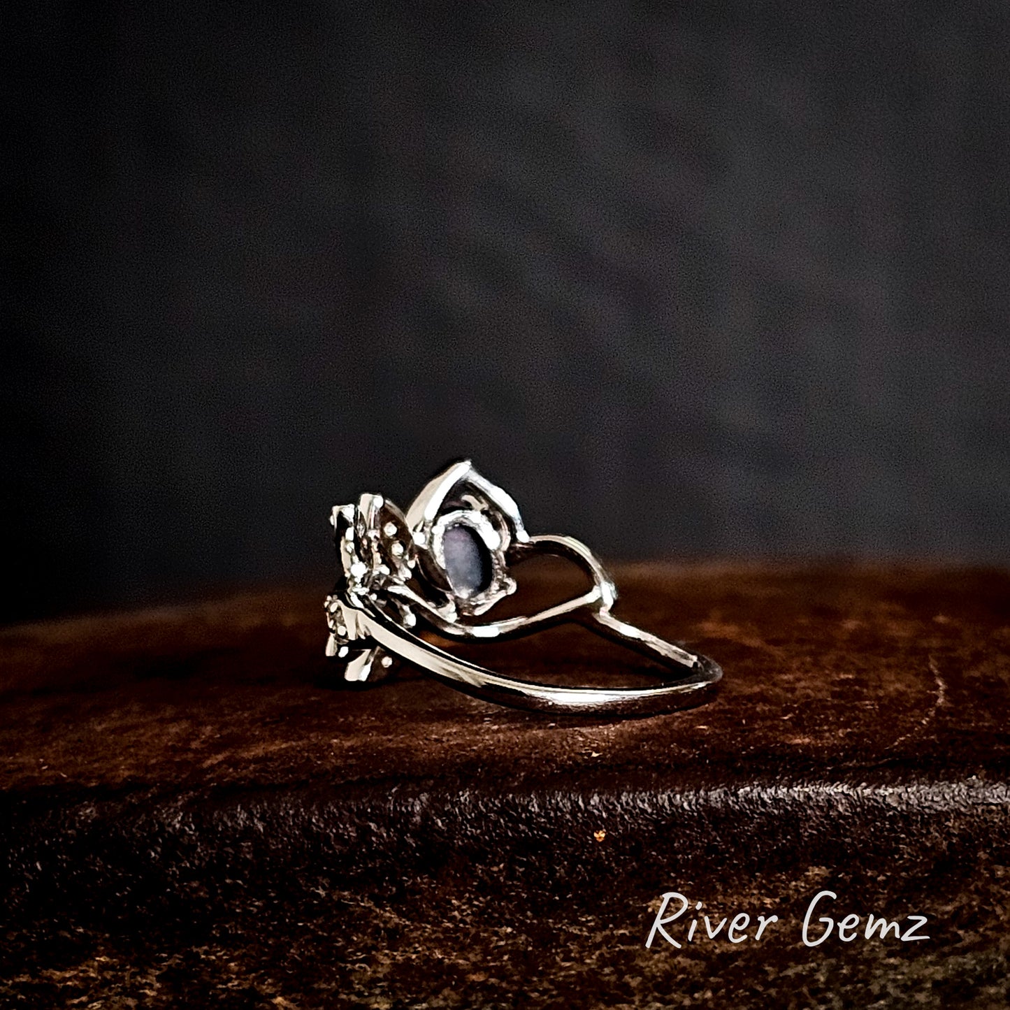 Rear of silver ring showing the dark tone of the black opal on a iron shoe anvil 'River Gemz' brand visible