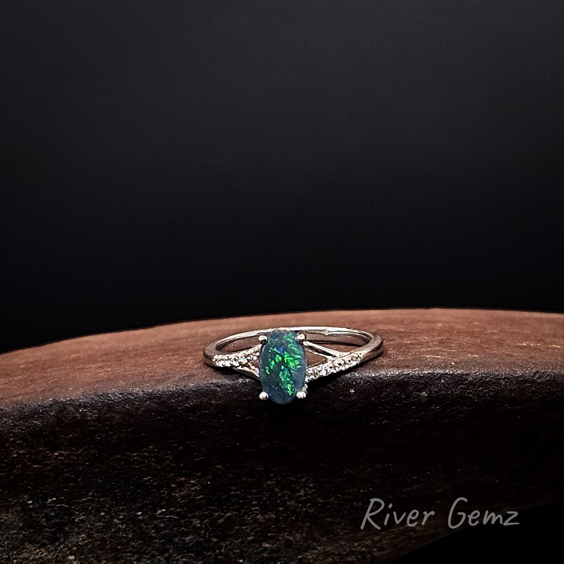 Vivid green in oval shaped dark opal claw set in sterling silver ring.
