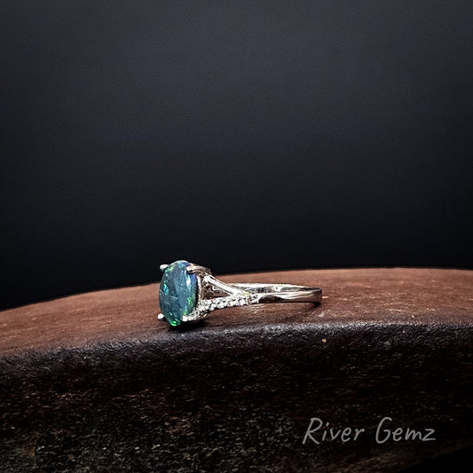 Oval shaped dark opal and white topaz set in silver ring.