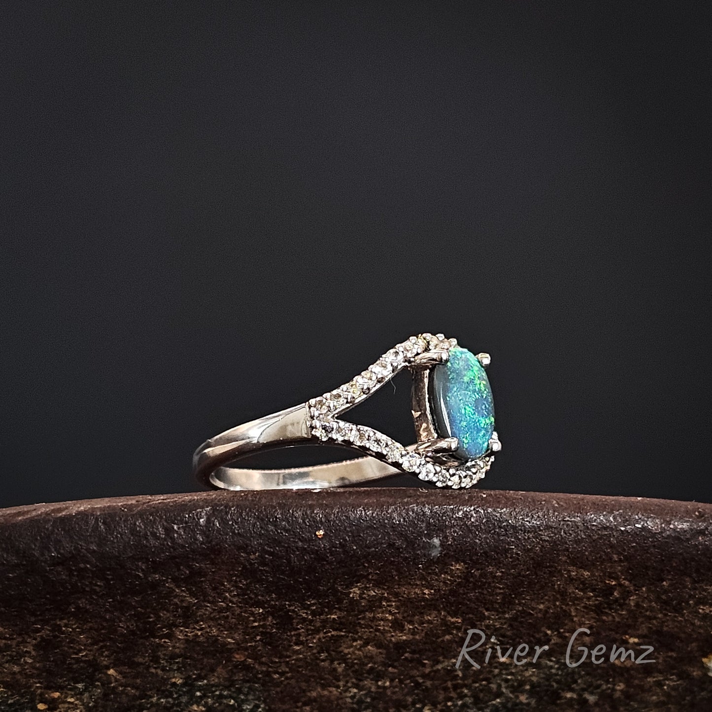 Silver ring with a blue gemstone on a dark background