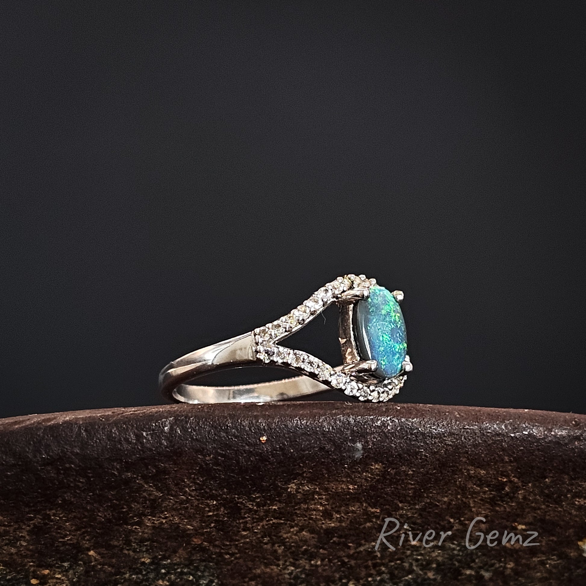 Silver ring with a blue gemstone on a dark background