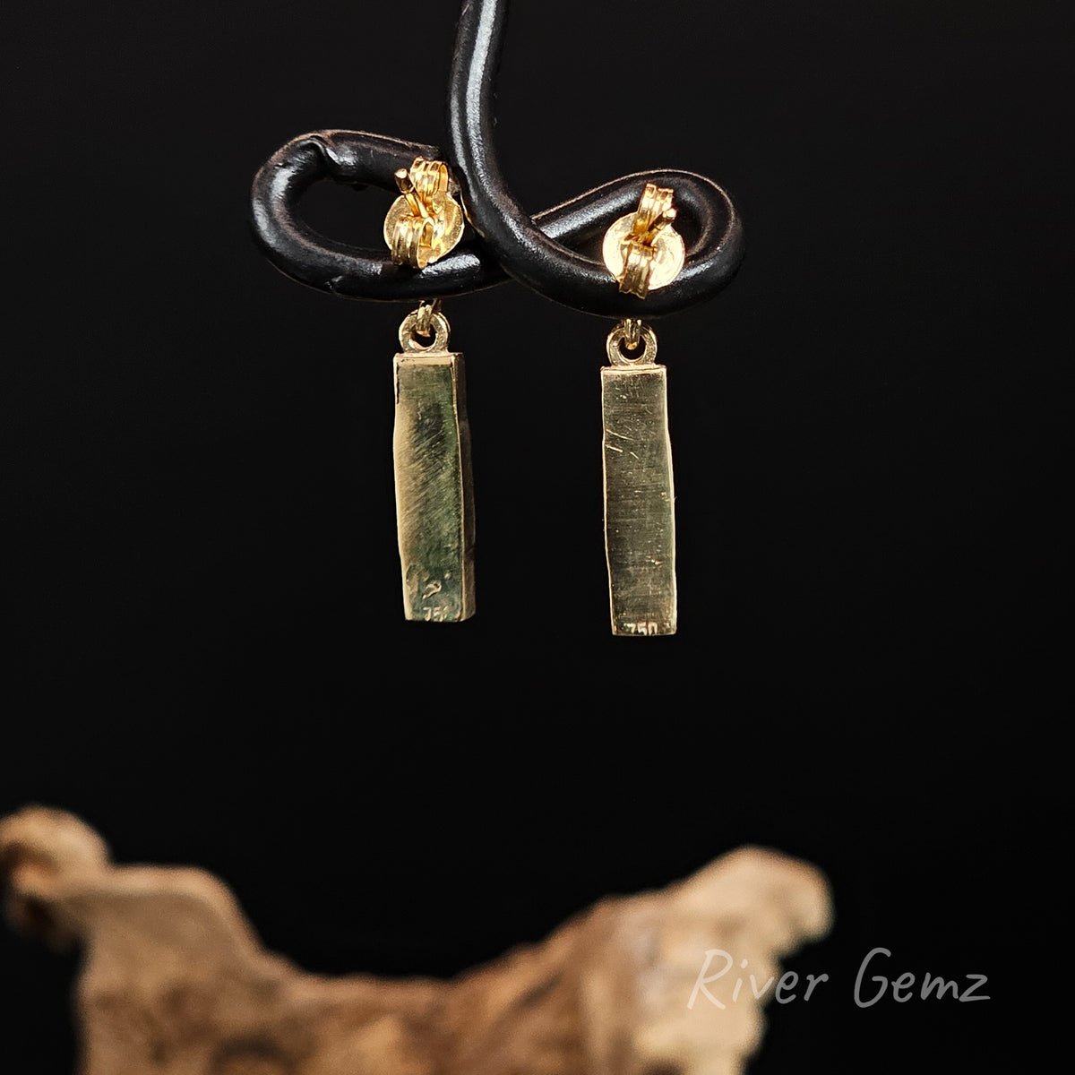Rear view of yellow gold dangly earrings shows the solid gold backing behind the inset opals.