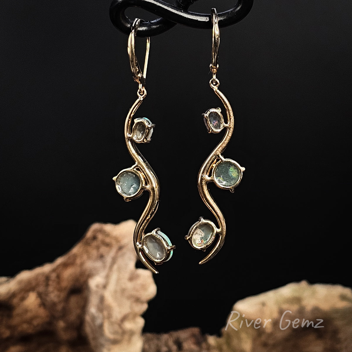 Rear view of the hook earrings show the dark base tone of the black opals set in them.