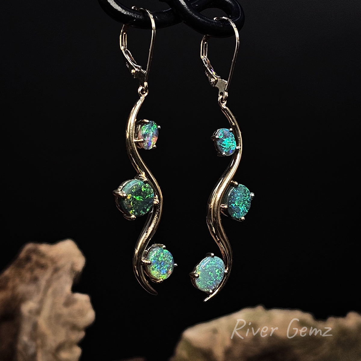 Yellow wave design hook earrings with 3 oval shaped stones claw set in them.