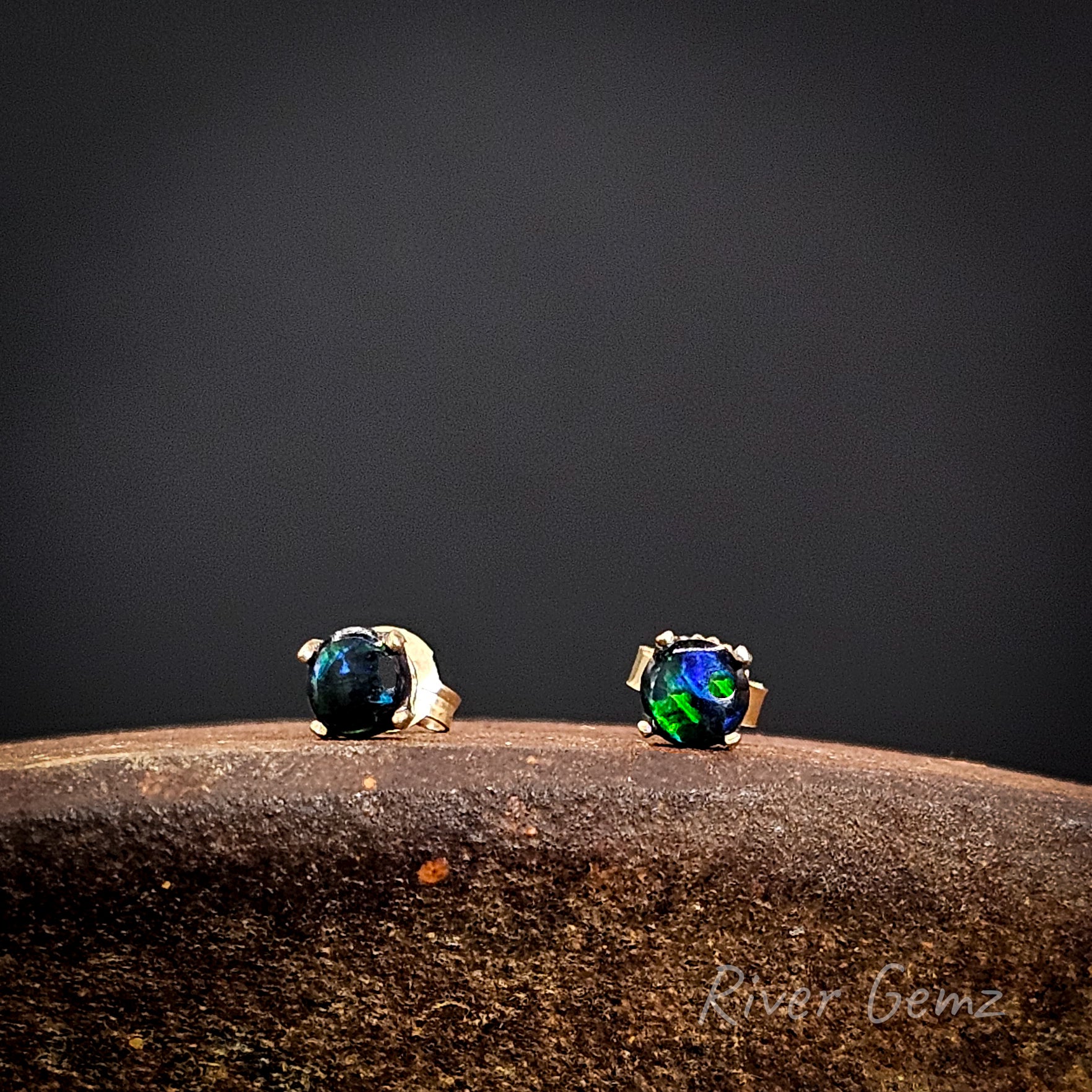 Pair of stud earrings with gemstones on a dark background