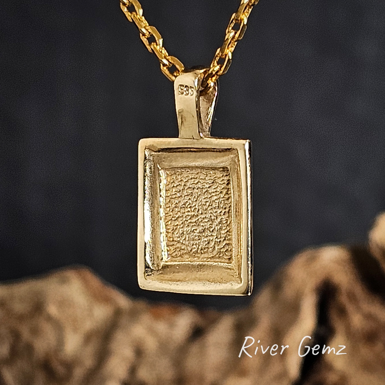 Back of the gold pendant necklace on a dark background with 'River Gemz' branding.