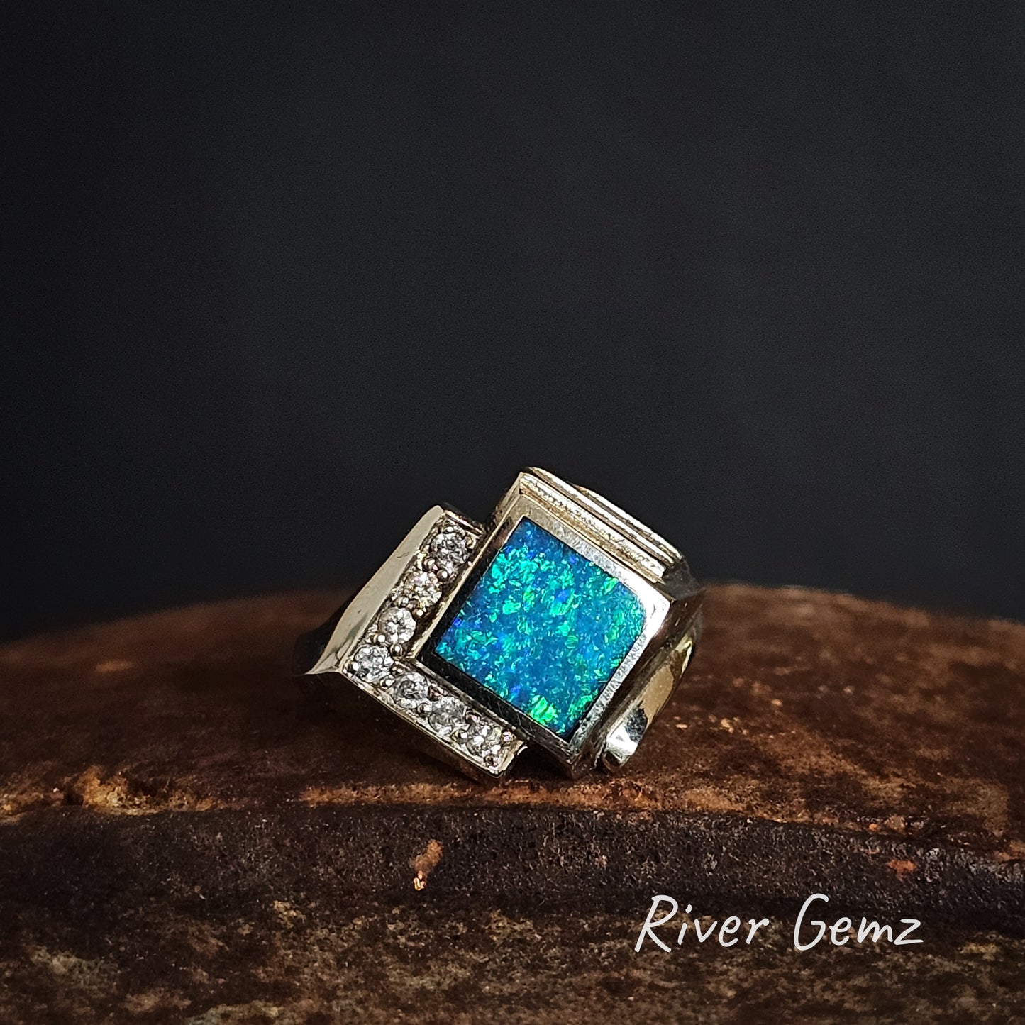 White gold ring with blue and green opal and pave diamonds on a dark background, branded 'River Gemz'.