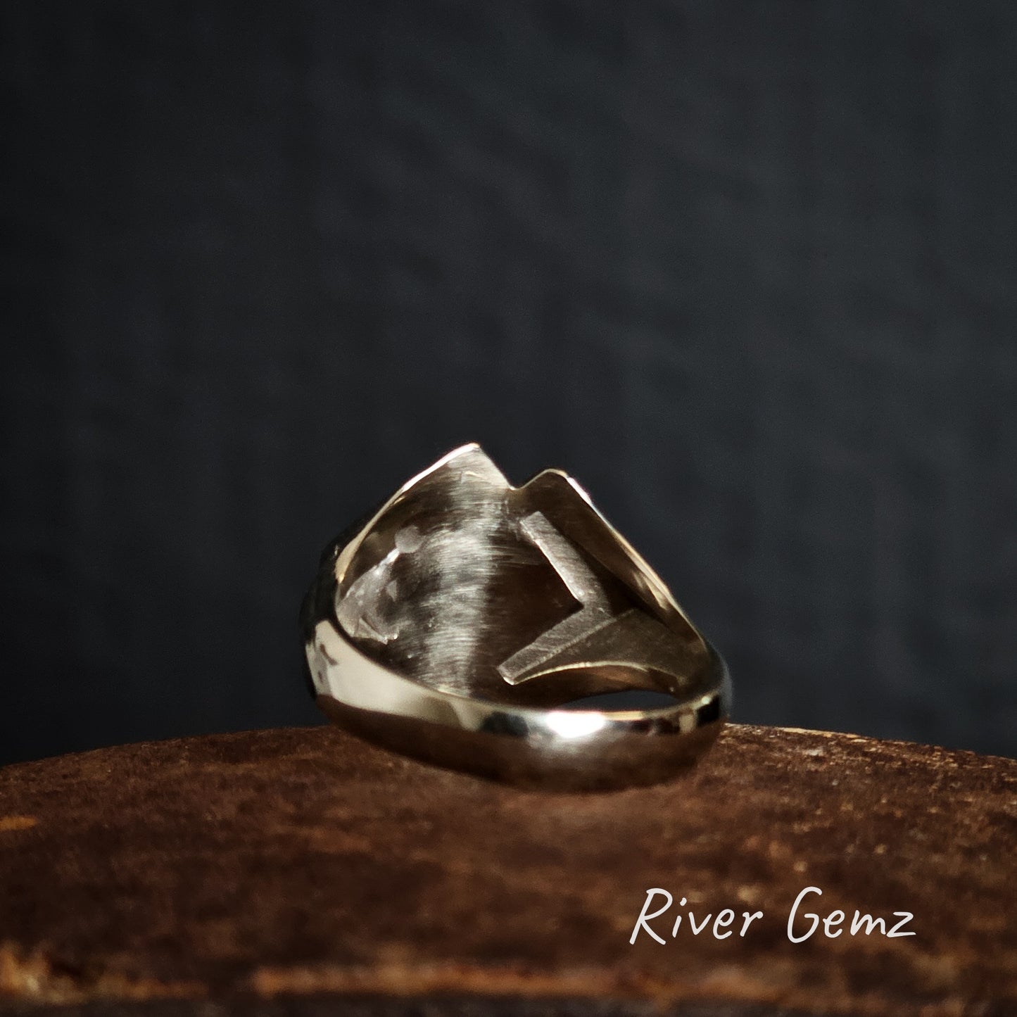 Back of white gold ring with a unique design on a dark background, featuring the brand 'River Gemz'.