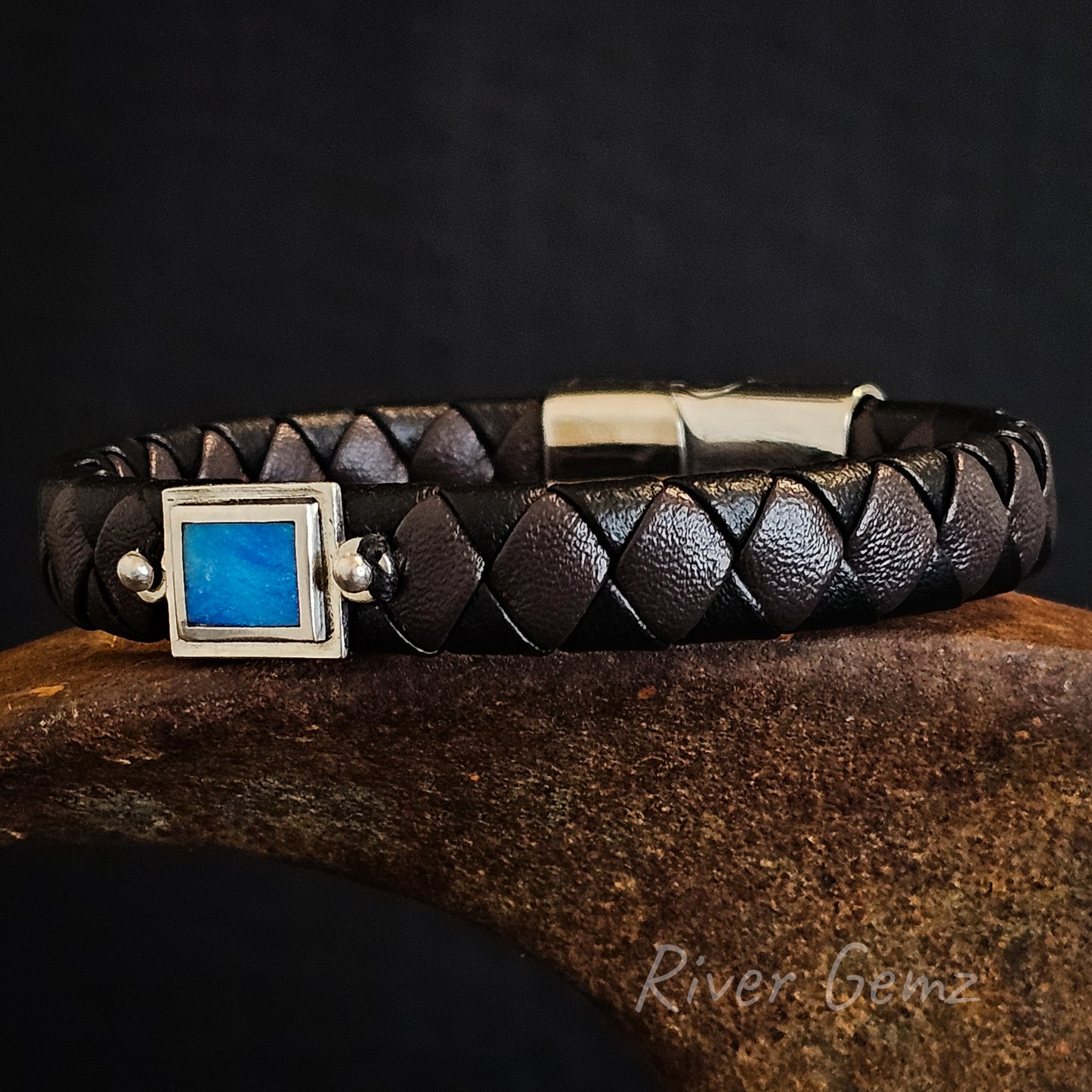 Dark brown and black braided leather bracelet with blue opal in rectangular shaped silver setting.