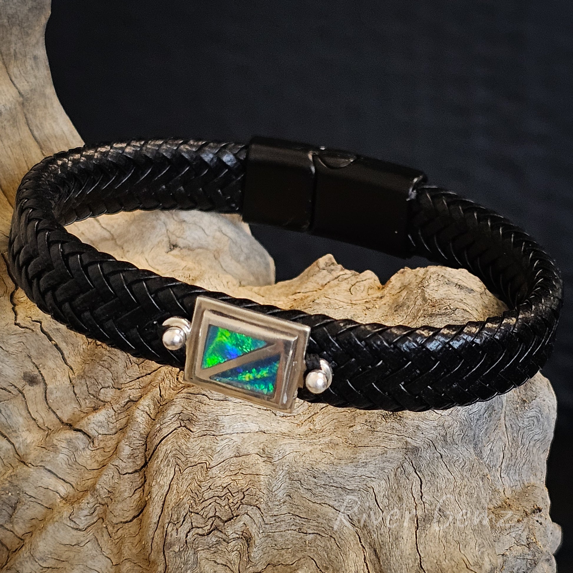 Black leather bracelet together with black clasp with blue and green black crystal opal besel set in sterling silver.