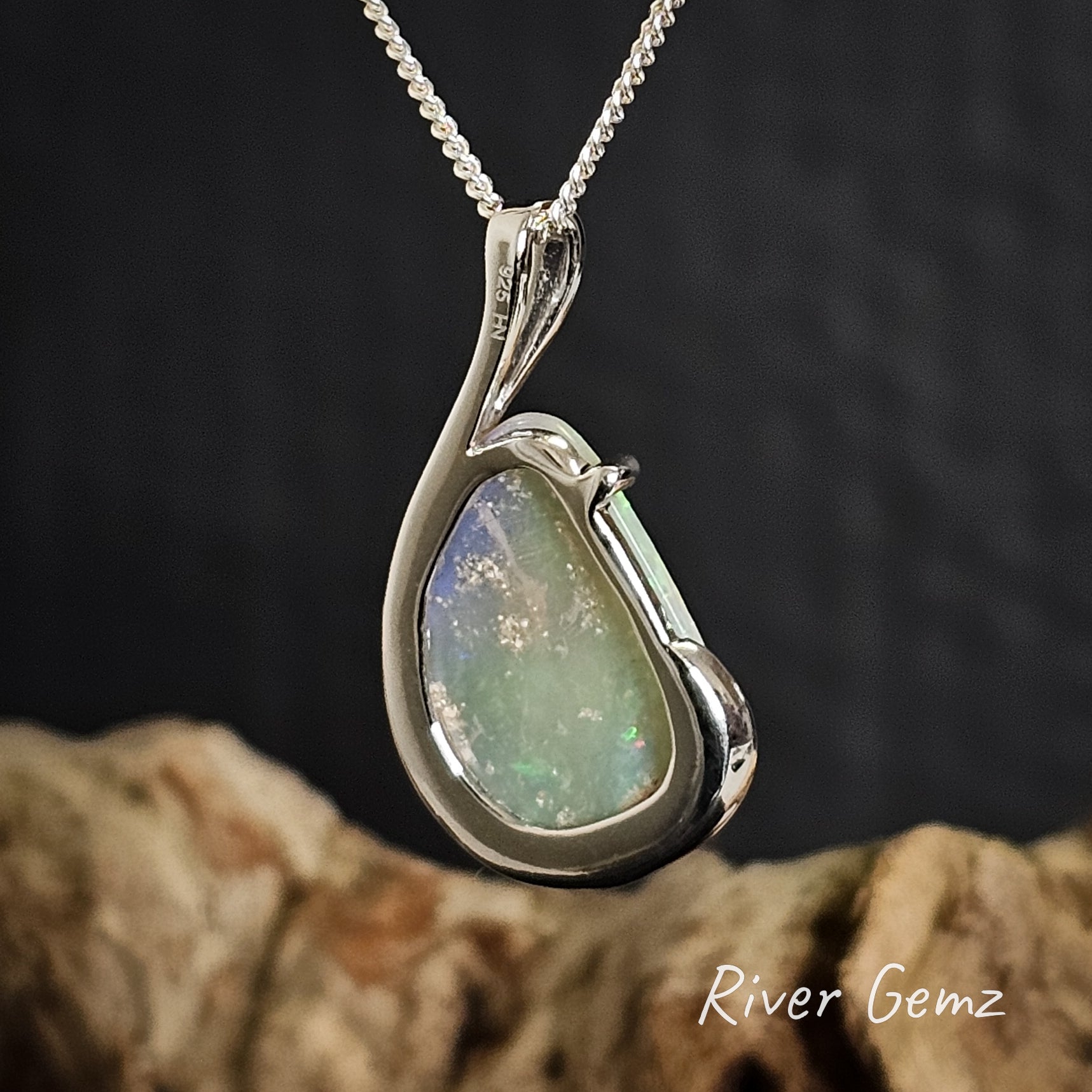 Rear view of opal pendant necklace on a dark background with 'River Gemz' branding.