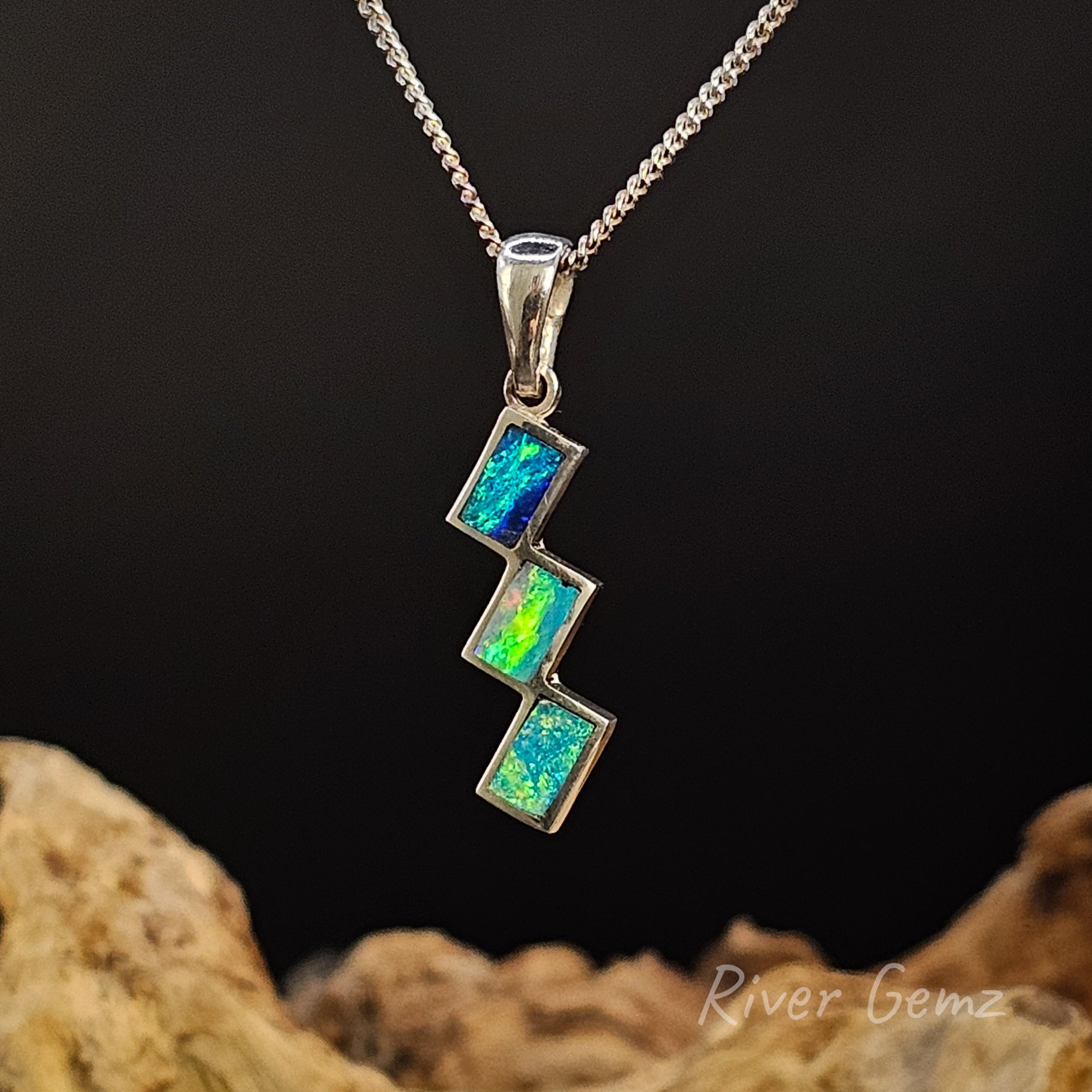 Multi-coloured opal necklace on a dark background with 'River Gemz' branding.