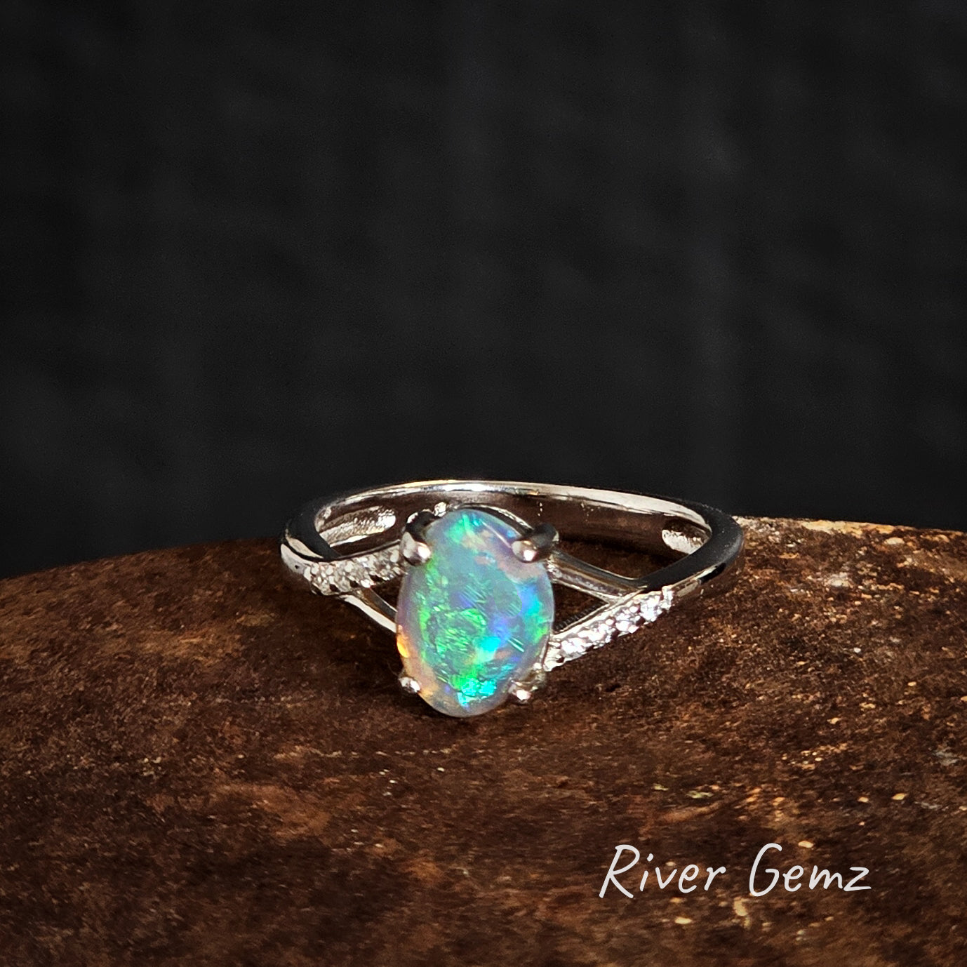 Free form cut blue and green crystal opal and white topaz set in silver ring.