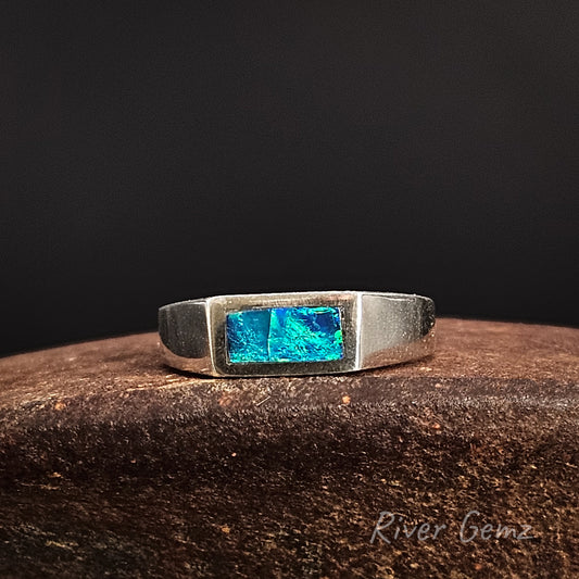 Silver ring with blue gemstone on a dark background