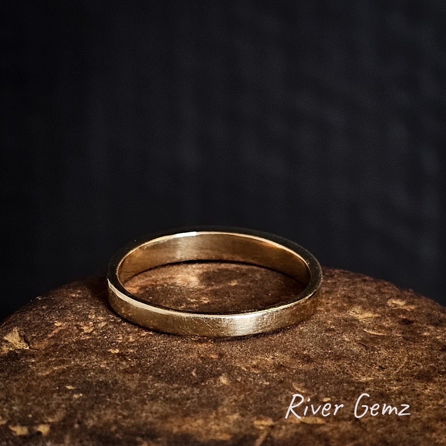 Rear view of the gold ring on a cast iron shoe anvil with 'River Gemz' branding.