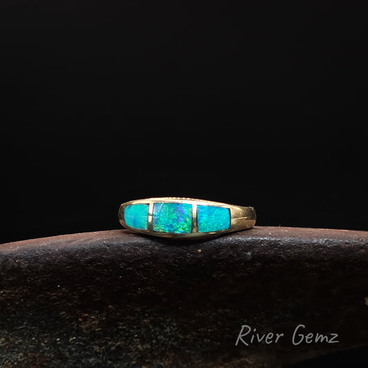 Gold ring with three blue & green opal stones on a dark background, branded 'River Gemz'.