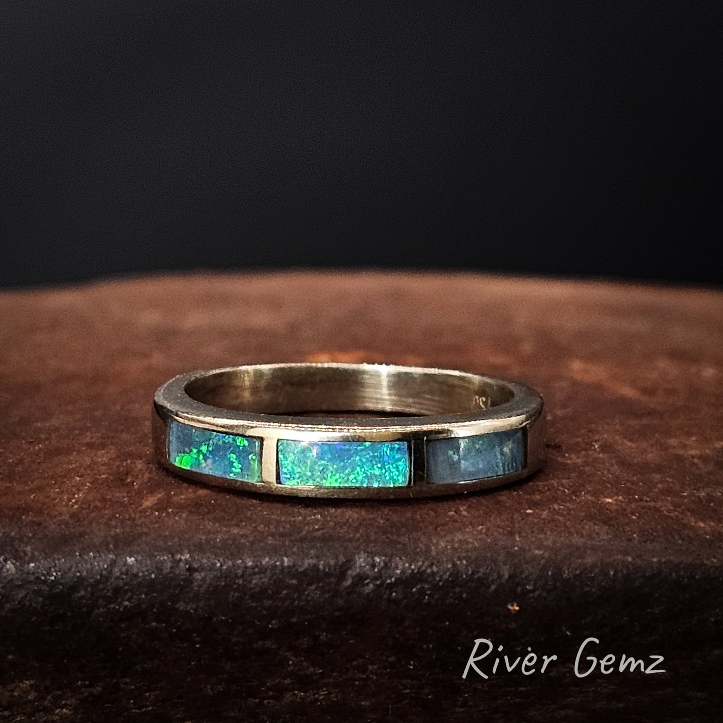 White gold ring with opal inlay on a dark surface, branded 'River Gemz'.