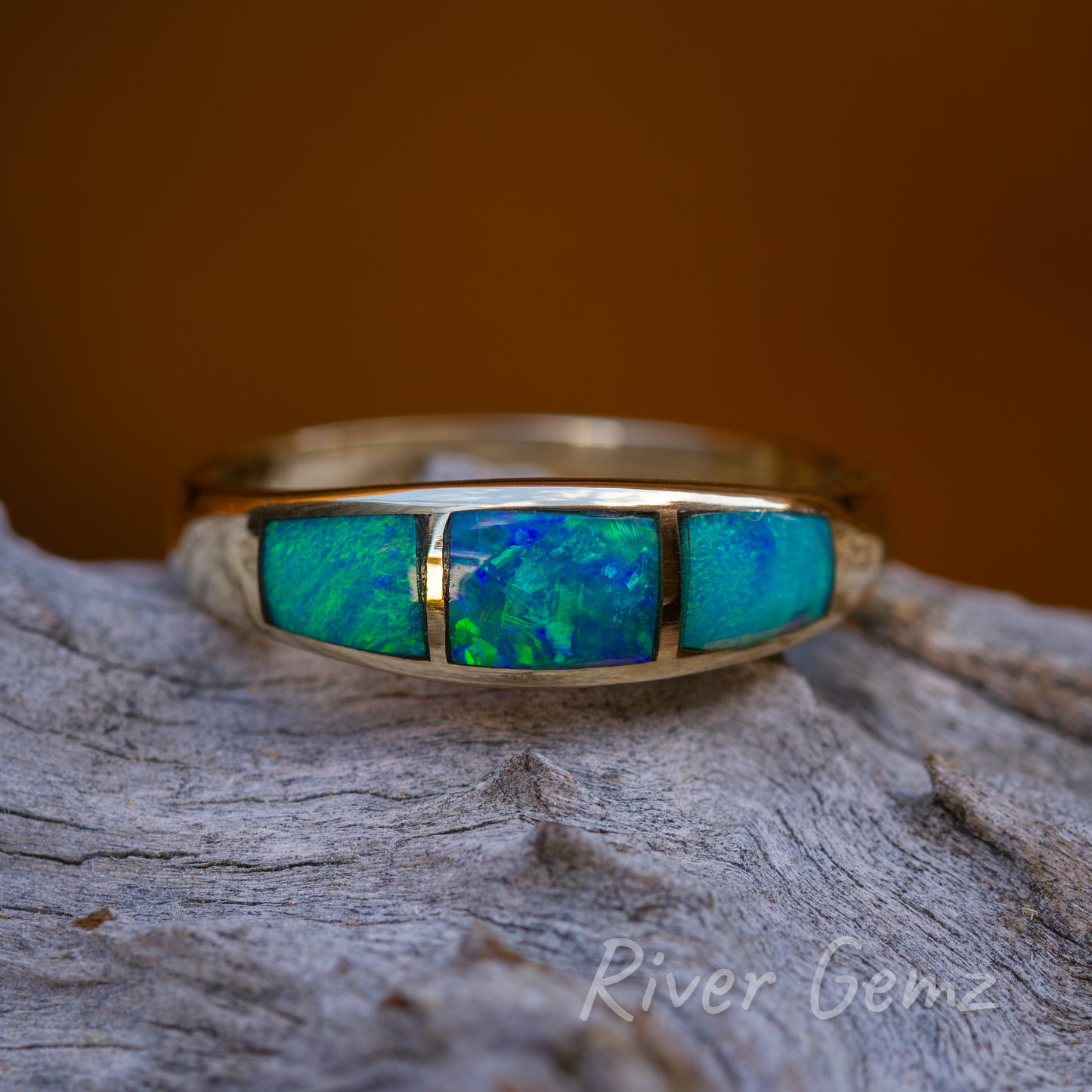 Front view of the 14K gold ring with 3 inlayed approximately rectangular shaped opals.