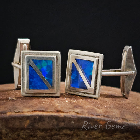 Two triangular opals forming a rectangular shape are inlaid into each silver cufflink.