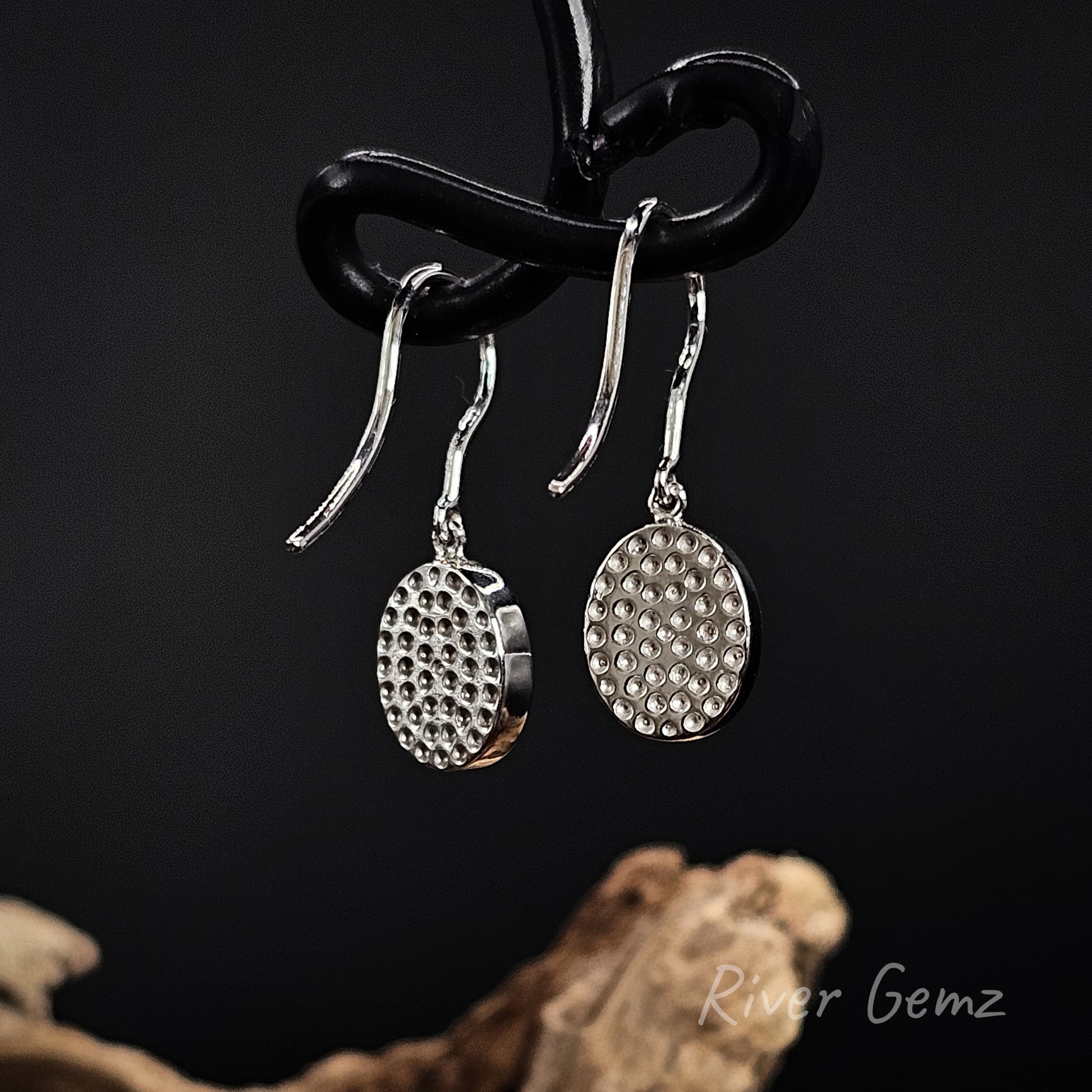 Back view of earrings show the silver backing behind the inlaid opals.