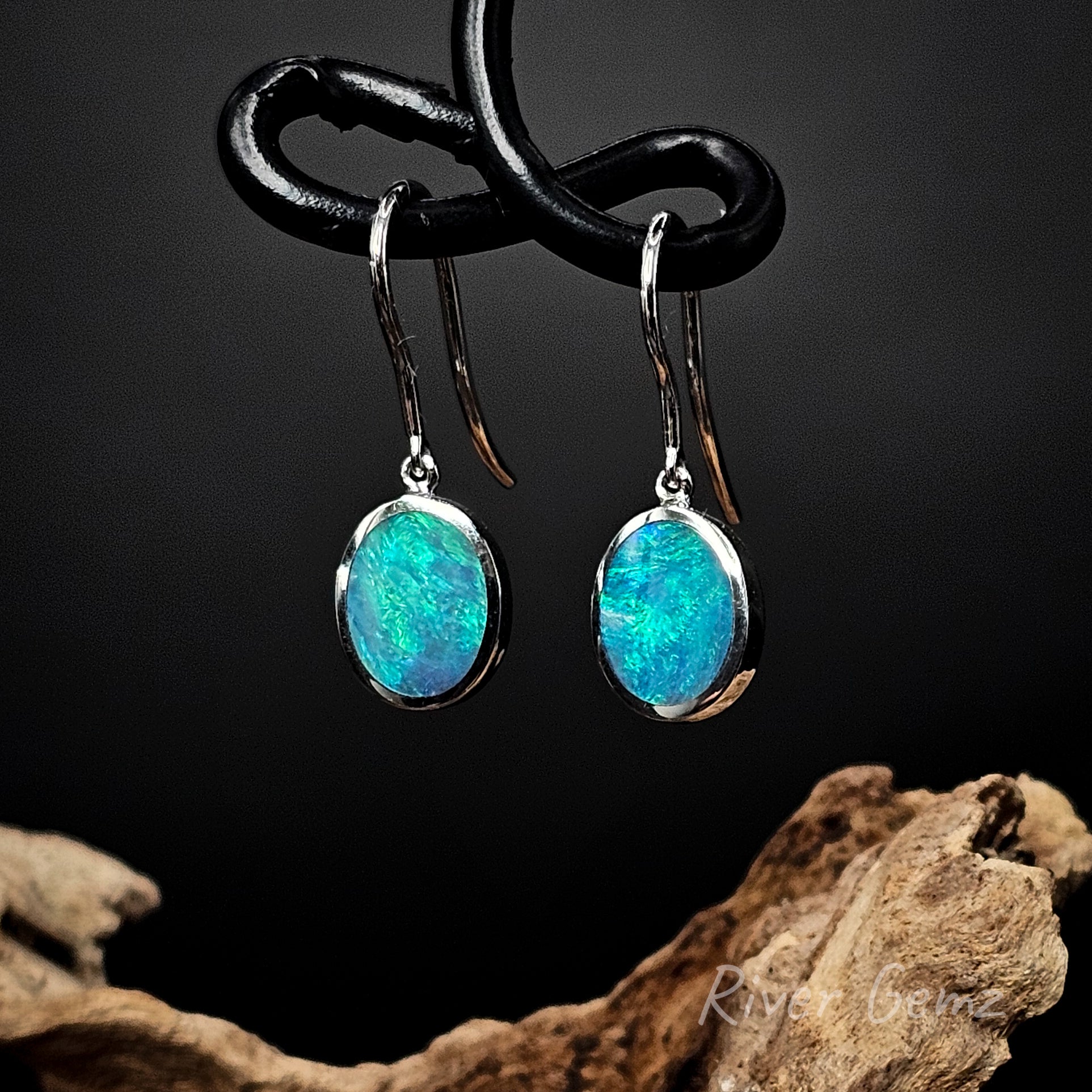 Oval shaped opals set in sterling silver dangly earrings.