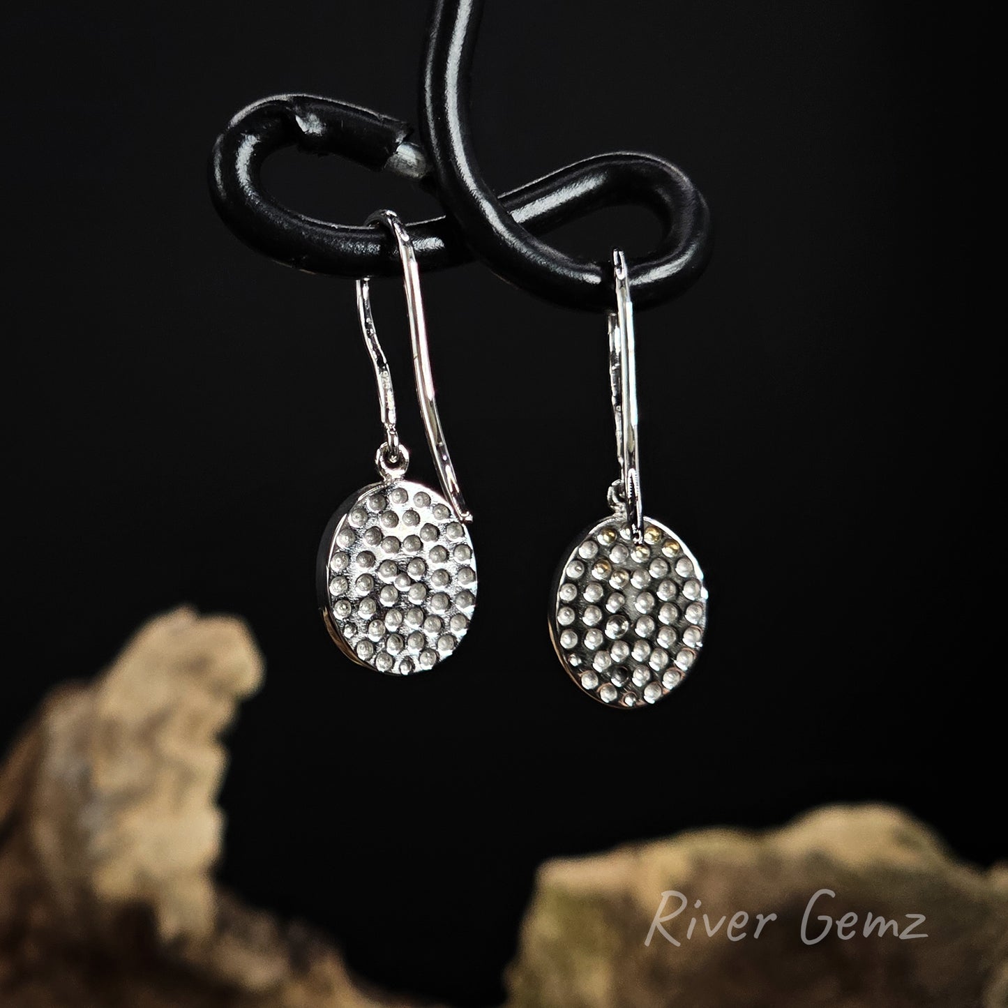 Rear view of earrings shows the silver backing behind the opals.