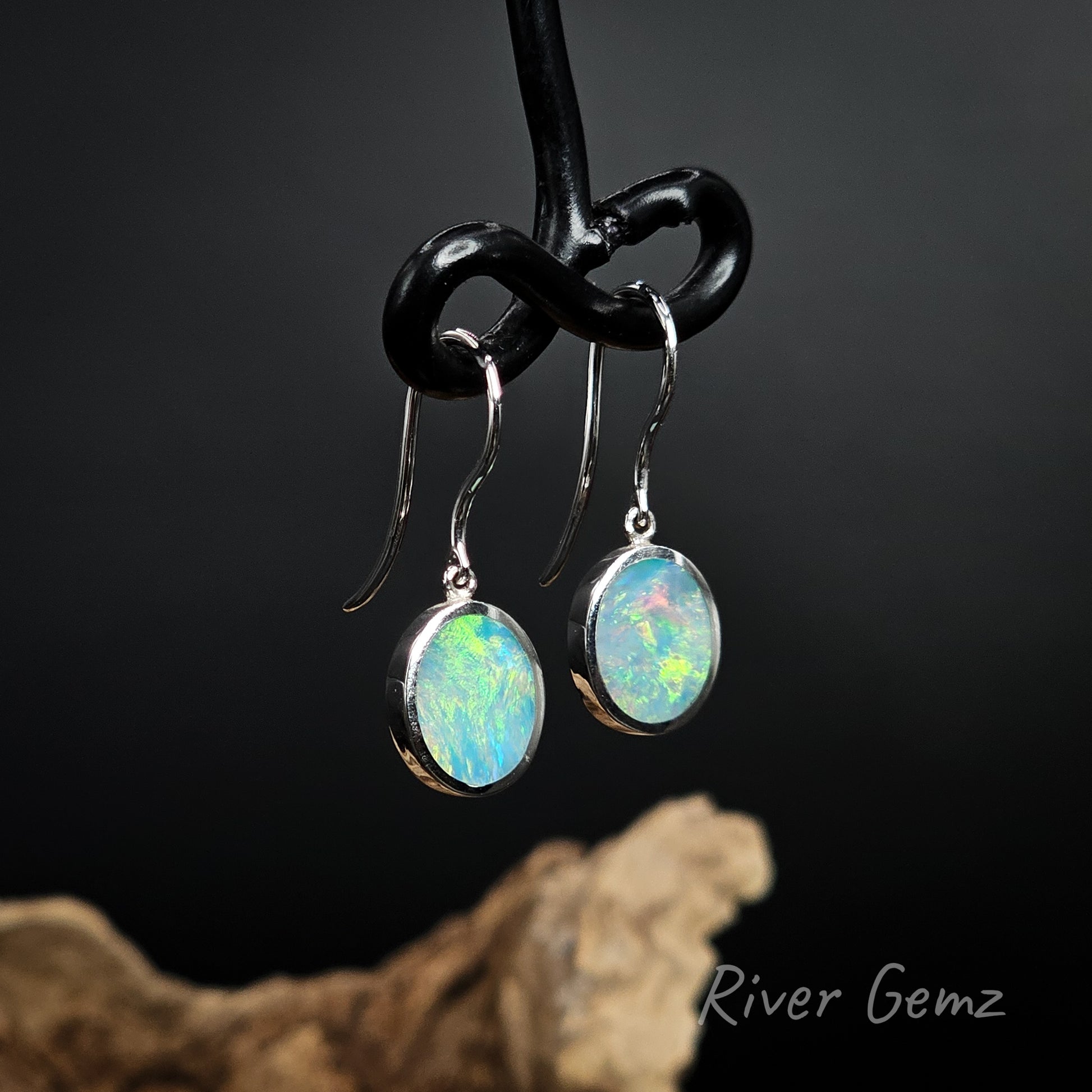 Multi-coloured opals besel set in sterling silver shepherd hook earrings.