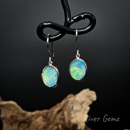 Oval shaped light opals set in silver French hooks.