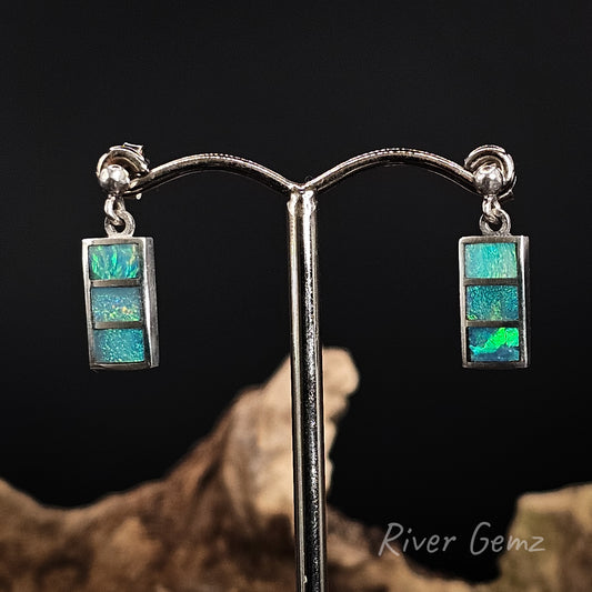 Pair of stud earrings with 3 rectangular shaped opals besel set in silver.