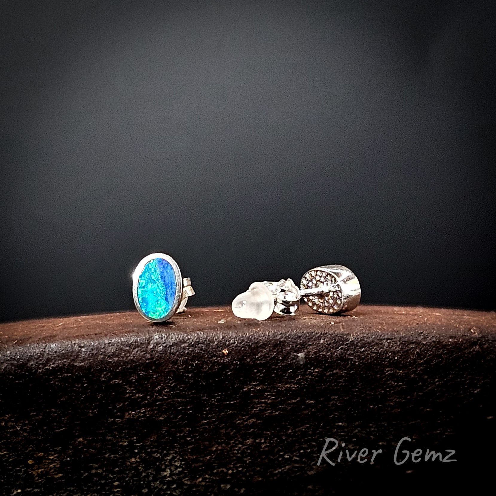 Pair of earrings with one stud shown from the rear revealing the solid silver backing used behind the opal.